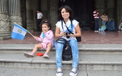 Una ni&ntilde;a de dos a&ntilde;os, acompa&ntilde;ado por su madre, agita una bandera frente al antiguo palacio de gobierno de Guatemala.