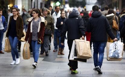 Un grupo de ciudadanos acarrea sus compras en el centro de Madrid.