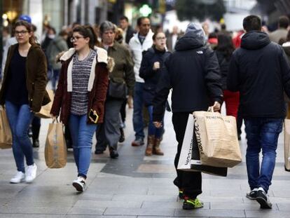Un grupo de ciudadanos acarrea sus compras en el centro de Madrid.