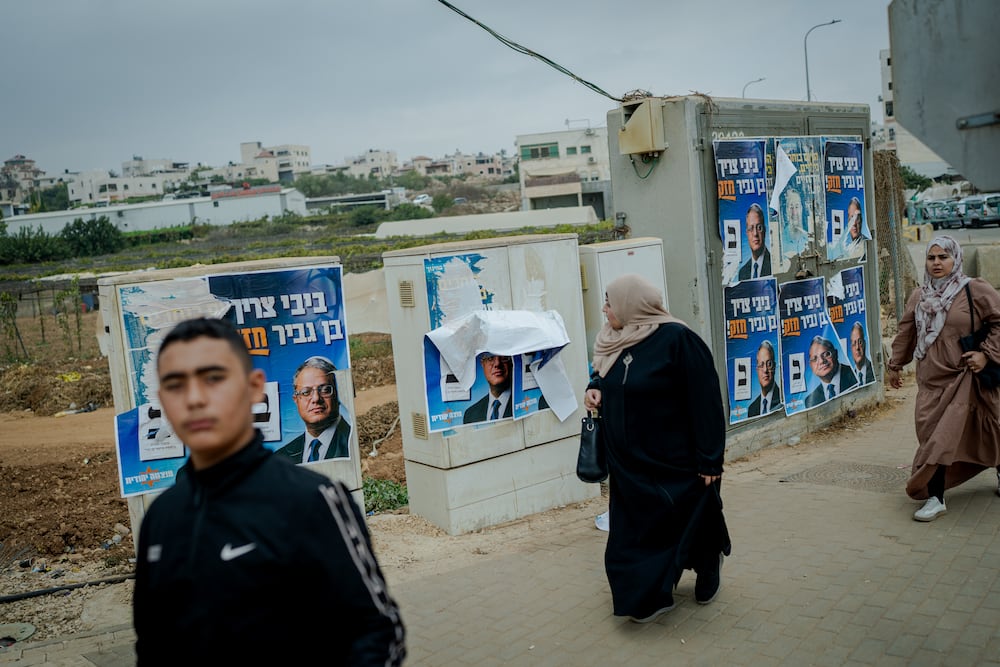 BEIT KAHIL, WEST BANK - OCTOBER 27: A Palestinian woman walks past campaign posters for Israel's National Security Minister and Otzma Yehudit party leader Itamar Ben Gvir, pasted on electrical utility boxes on October 27, 2026 in Beit Kahil, West Bank. Voting is underway to choose 120 members of the Knesset, which will determine the make-up of the government that succeeds incumbent Israeli Prime Minister Benjamin Netanyahu's right-wing coalition. Around 500,000 Israeli settlers living in the occupied West Bank and are entitled to cast ballots in Israel's elections, while 3.1 million Palestinians in the territory are not eligible to vote. The legislative elections are the first to be held since the Hamas-led attacks against Israel on October 7, 2023. (Photo by Erik Marmor/Getty Images)
