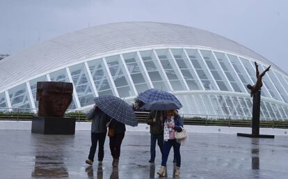 Turistas se protegen de la lluvia en Valencia.