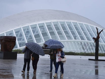 Turistas se protegen de la lluvia en Valencia.
