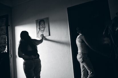 Teresa Osorio, días después del asesinato de su segundo hijo, acaricia la foto del primero que le mataron.