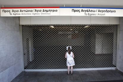 Una mujer, delante de una estación de metro cerrada por la huelga en Atenas