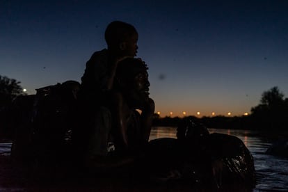 Un hombre haitiano y su hijo cruzan el Río Bravo desde Ciudad Acuña (Coahuila) hasta Del Río (Texas), este jueves.