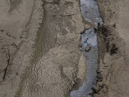 Um homem cruza o Embalse Barrios de Luna, em León, Espanha, em outubro de 2017.