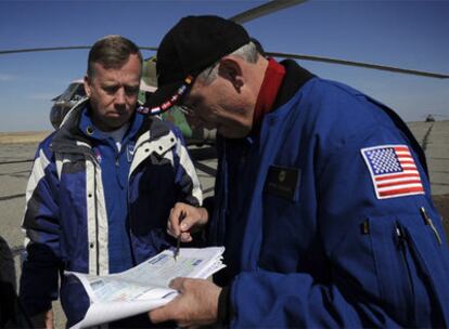 Oficiales de la NASA examinan en un mapa el lugar exacto donde ha aterrizado la nave espacial 'Soyuz'.