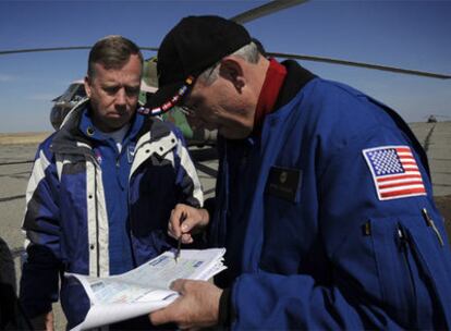 Oficiales de la NASA examinan en un mapa el lugar exacto donde ha aterrizado la nave espacial &#39;Soyuz&#39;.