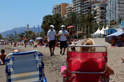 Una pareja de vigilantes recorren la playa de La Malagueta (Málaga).