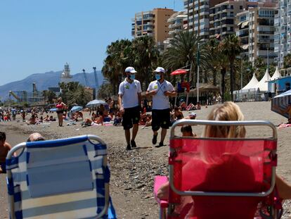 Una pareja de vigilantes recorren la playa de La Malagueta (Málaga).