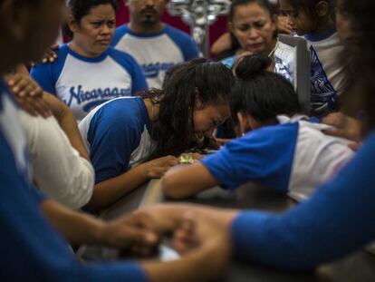 Amigos de Gerald Vázquez lloran sobre su ataúd durante su funeral.