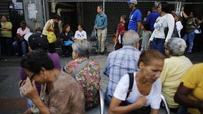 Venezolanos esperan en la entrada de un supermercado de Caracas, Venezuela, el 23 de agosto.