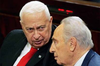 Ariel Sharon (izquierda) habla con Simón Peres durante la sesión parlamentaria de ayer.