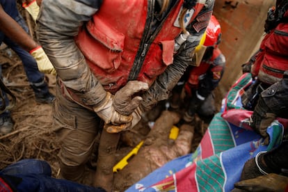 Los miembros de rescate llevan el cuerpo de una persona que murió durante el deslizamiento de tierra.