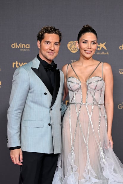 David Bisbal eligió un traje de chaqueta color claro y solapas negras firmado por Boglioli. Su pareja, Rosana Zanetti, con vestido con adornos metalizados y falda terminada con plumas.