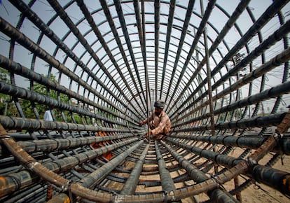 Un ferrallista de Lahoe (Pakistán) trabaja sobre en la construcción de un paso elevado.