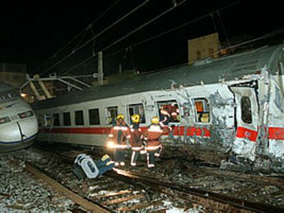 Un grupo de bomberos en el momento de entrar en el tren Catalunya Express, junto al primer vagón del Euromed, a la izquierda.