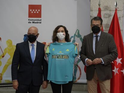 La presidenta de la Comunidad de Madrid, Isabel Díaz Ayuso, posa con una camiseta durante el acto por el que recibe el título de Maratoniana de Honor por parte de la Asociación Deportiva Maratón Popular de Madrid.
