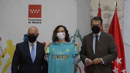 La presidenta de la Comunidad de Madrid, Isabel Díaz Ayuso, posa con una camiseta durante el acto por el que recibe el título de Maratoniana de Honor por parte de la Asociación Deportiva Maratón Popular de Madrid.