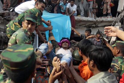 Los equipos de recate sacan a un hombre herido de los escombros del edificio de ocho plantas derrumbado en la ciudad de Dacca (Bangladesh).