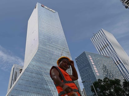 Un trabajador camina frente a las oficinas centrales de Evergrande, en Shenzhen, al sureste de China, en una imagen de archivo.