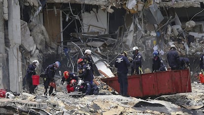 Un equipo de rescate busca a supervivientes entre los escombros del edificio de Surfside, este sábado. Los residentes de la torre norte del complejo residencial Champlain Tower han comenzado una evacuación de carácter voluntario tras el colapso del viernes de su edificio anexo, que hasta ahora ha dejado al menos cinco muertos y 156 desaparecidos.