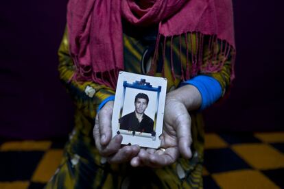 In this Tuesday, Jan. 24, 2017 photo, Heven Daood, 39, a Syrian refugee from Tell-Tawil in al-Hasaka, shows a photograph of her husband Reiad, 45, at her shelter in Ritsona refugee camp, Greece. "I have this photograph with me for the last 10 years, it is a very precious picture, my husband used to travel a lot for work and this image always remained close to my heart." Heven said. (AP Photo/Muhammed Muheisen)