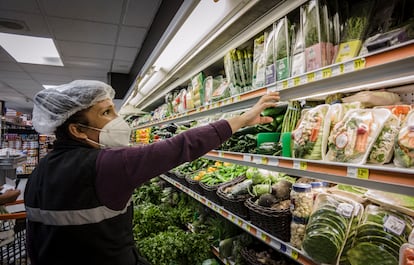 Una empleada de un supermercado en la Colonia Roma, Ciudad de México, reorganiza un estante.