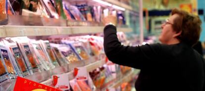 Una mujer selecciona productos en un supermercado.