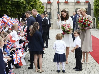 El presidente polaco, Andrzej Duda, junto al príncipe Guillermo y la primera dama polaca, Agata Kornhauser-Duda, junto a Catalina, saludan a unos niños antes de su reunión en el palacio presidencial de Varsovia (Polonia).