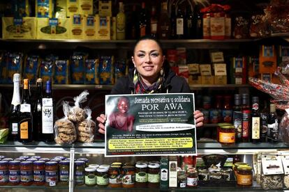 Marcella Iaravone, en su puesto del Mercat Central y mostrando el cartel para recaudar fondos para Awa.