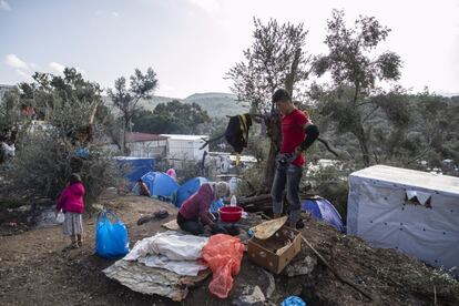 Uma família faz pão em um forno de barro localizado no piso da nova área do olival Moria.