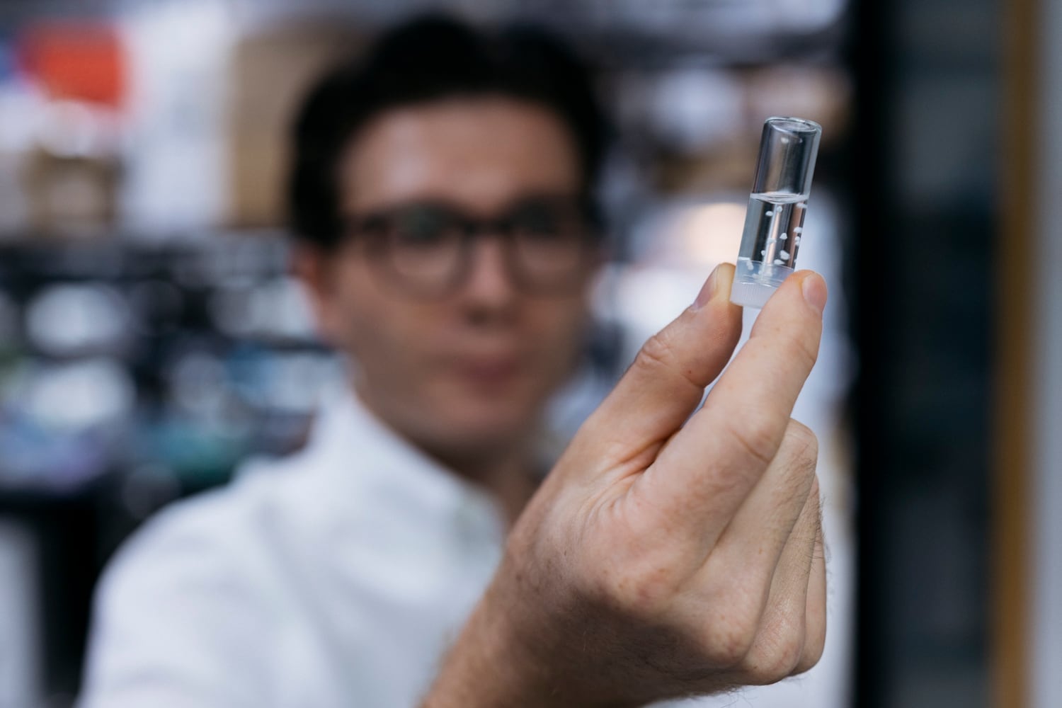 El médico Sergiu Pasca sostiene un vial con organoides cerebrales humanos.