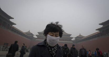 Una mujer lleva una mascara protectora contra la contaminación mientras visita la Ciudad Prohibida de Pekín, en China.