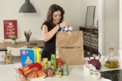Una mujer saca de la bolsa de Amazon Prime Now los productos adquiridos en la tienda online de esta compañía.