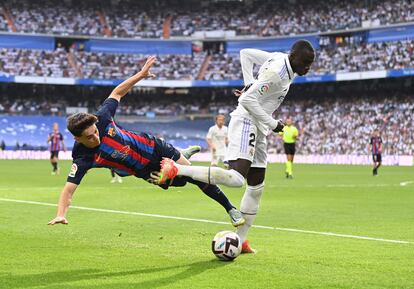 Gavi, a la izquieda, y Ferland Mendy, tras una jugada.