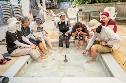 Unos peregrinos coreanos se refrescan en la fuente de un albergue, este jueves en Logroño.
