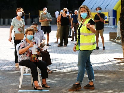 Varias personas esperan para acceder a la zona de realización de PCR durante el primer día de cribados masivos de covid-19 en El Raval de Barcelona, en septiembre.