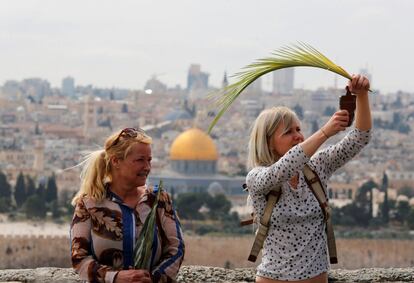 Fieles cristianas con hojas de palma mientras participan en una procesión del Domingo de Ramos en el Monte de los Olivos en Jerusalén, el 9 de abril de 2017.