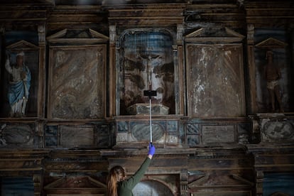 Aurora Galisteo se ayuda de un palo selfie para tomar fotografías de las zonas más altas de los retablos.