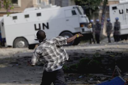 Un haitiano arroja una piedra a un vehículo de la ONU durante una protesta en Puerto Príncipe.