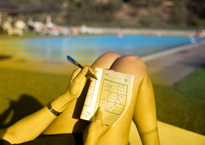 Una mujer hace un sudoku en una piscina de Barcelona el 25 de julio del 2023.