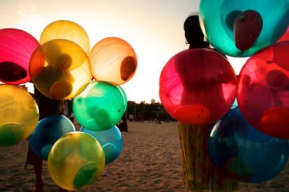 Niños con globos de colores en una playa de Bombay (India).