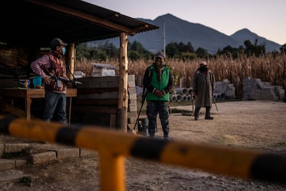 Tres hombres armados vigilan la entrada a la comunidad de Crescencio Morales, el 8 de diciembre.