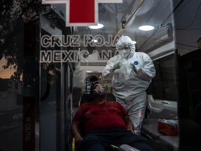 Un paramédico de Cruz Roja estabiliza en la ambulancia a un hombre en situación grave por covid-19.