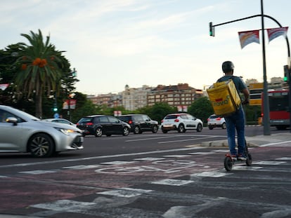 Un repartido cruza este jueves el carril bici de plaza Zaragoza en un patinete eléctrico.