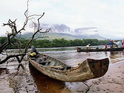 Estas canoas, llamadas curiara por los indios pemones, conducen a los turistas hasta el Salto del Ángel. Entre la niebla, al fondo, la silueta de los tepuyes.