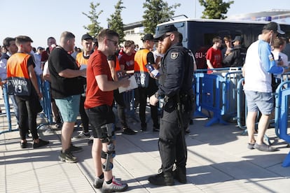 Un miembro de la Policía Nacional informa a un hincha que su entrada es falsa durante un control de seguridad en el acceso al estadio Metropolitano, en Madrid.