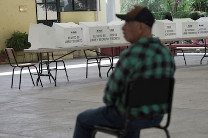 Un funcionario de casilla espera a los votantes en Morelia.