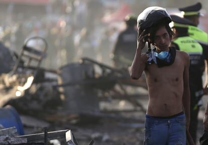 Rapaz tira o capacete durante os trabalhos de resgate das vítimas da explosão no mercado pirotécnico de Tultepec.